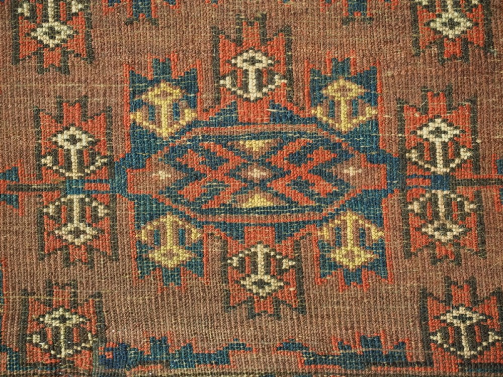 A horizontal rectangular antique wool torba bag face featuring central diamond-shaped Kepse gul motifs in deep red, indigo blue, and ivory framed by a geometric border. View VIII