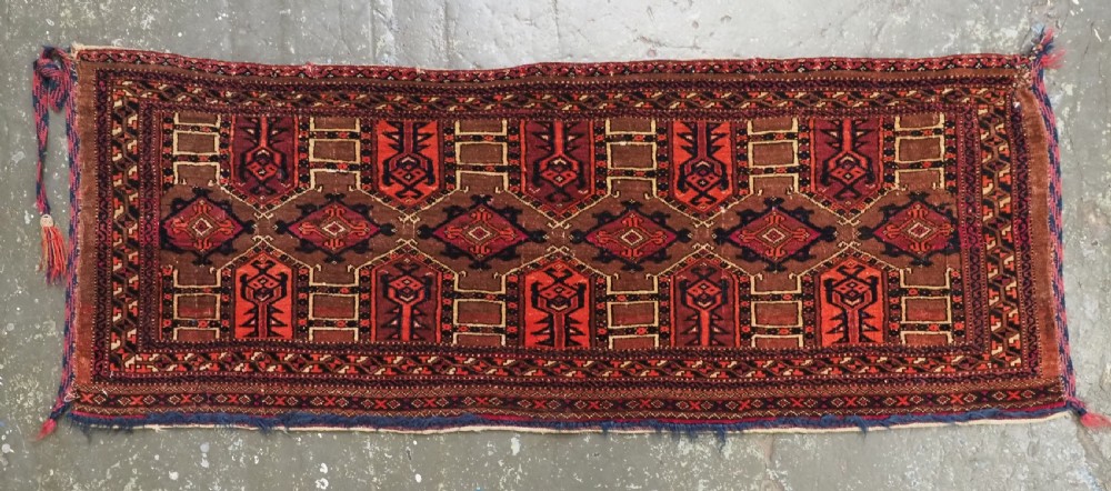 An antique horizontal Saryk Turkmen torba face featuring geometric Kedjebe motifs woven in deep red, dark brown, and cream wool tones. View II