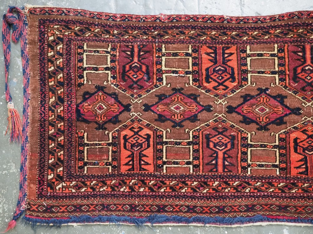 An antique horizontal Saryk Turkmen torba face featuring geometric Kedjebe motifs woven in deep red, dark brown, and cream wool tones. View III