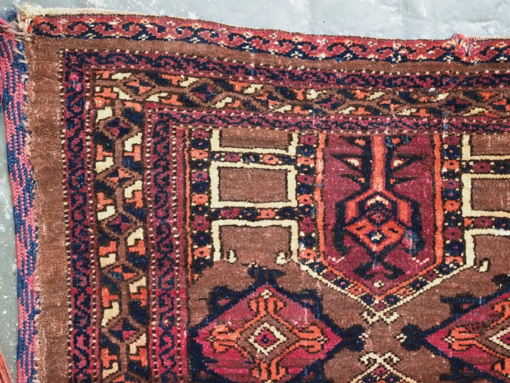 An antique horizontal Saryk Turkmen torba face featuring geometric Kedjebe motifs woven in deep red, dark brown, and cream wool tones. View VI