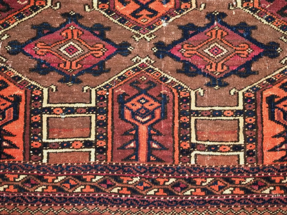 An antique horizontal Saryk Turkmen torba face featuring geometric Kedjebe motifs woven in deep red, dark brown, and cream wool tones. View IX