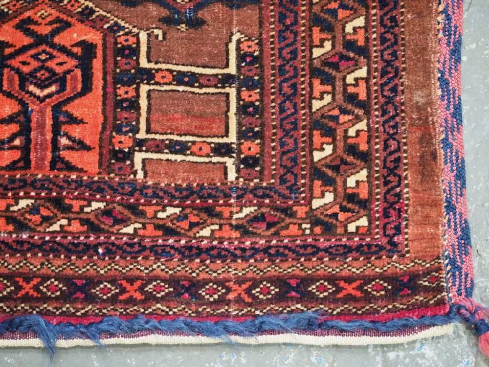 An antique horizontal Saryk Turkmen torba face featuring geometric Kedjebe motifs woven in deep red, dark brown, and cream wool tones. View X