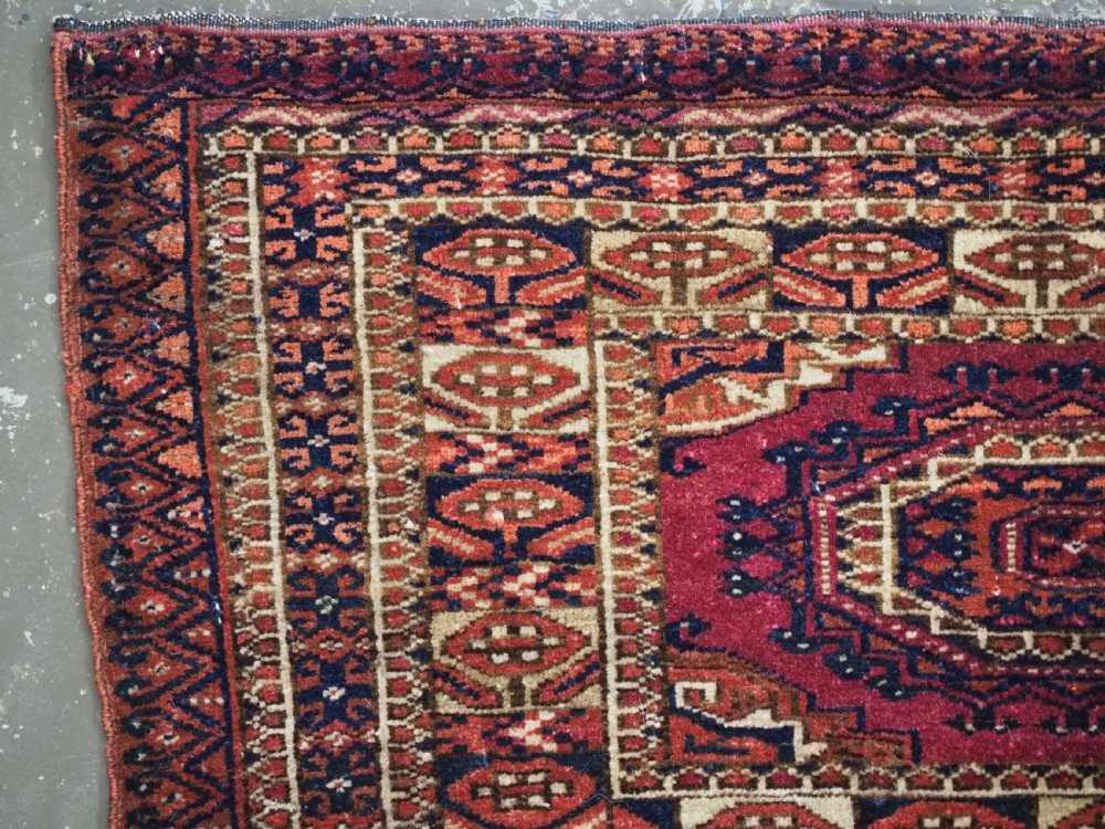 An antique rectangular Tekke Turkmen torba face featuring three central octagonal Salor guls on a deep red wool field with geometric borders and lower fringe. View VI