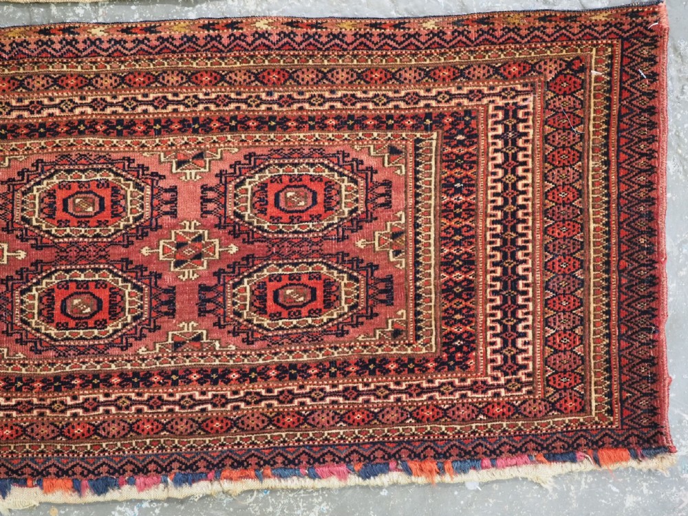 A pair of long rectangular hand-knotted dark red wool Tekke Turkmen torba bag faces featuring geometric octagonal Salor guls and detailed patterned borders. View V