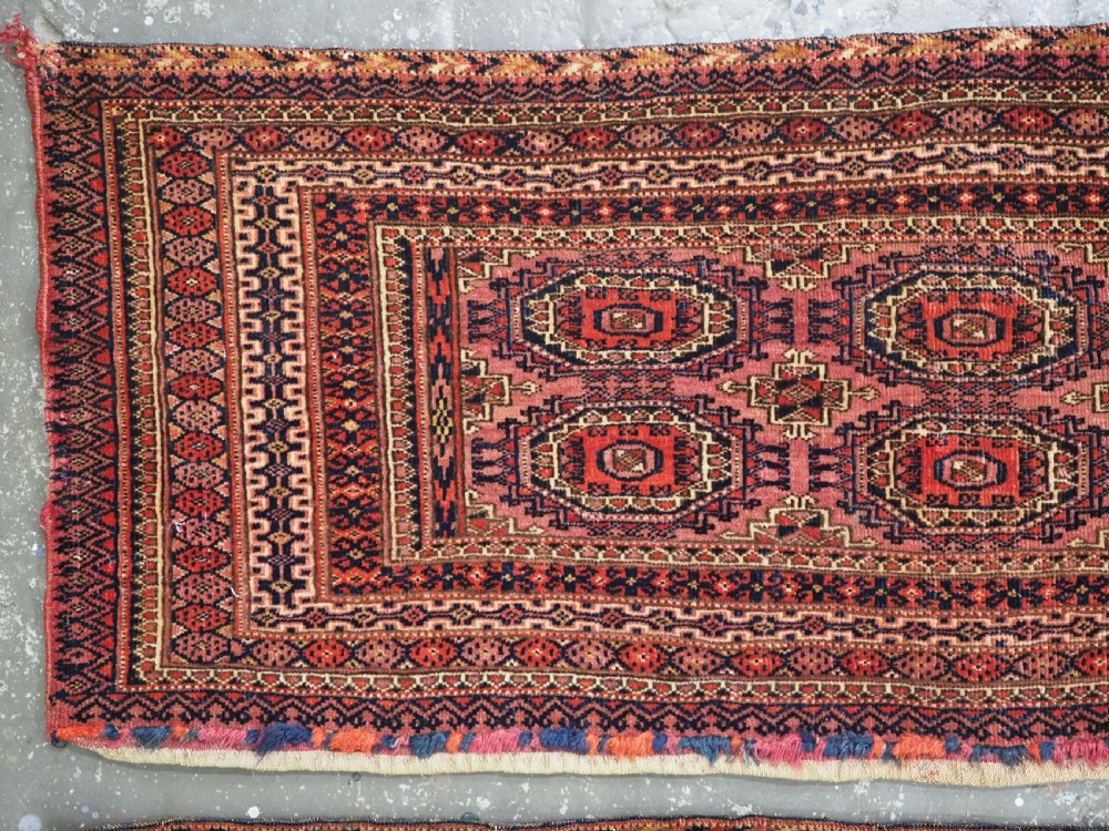 A pair of long rectangular hand-knotted dark red wool Tekke Turkmen torba bag faces featuring geometric octagonal Salor guls and detailed patterned borders. View VII