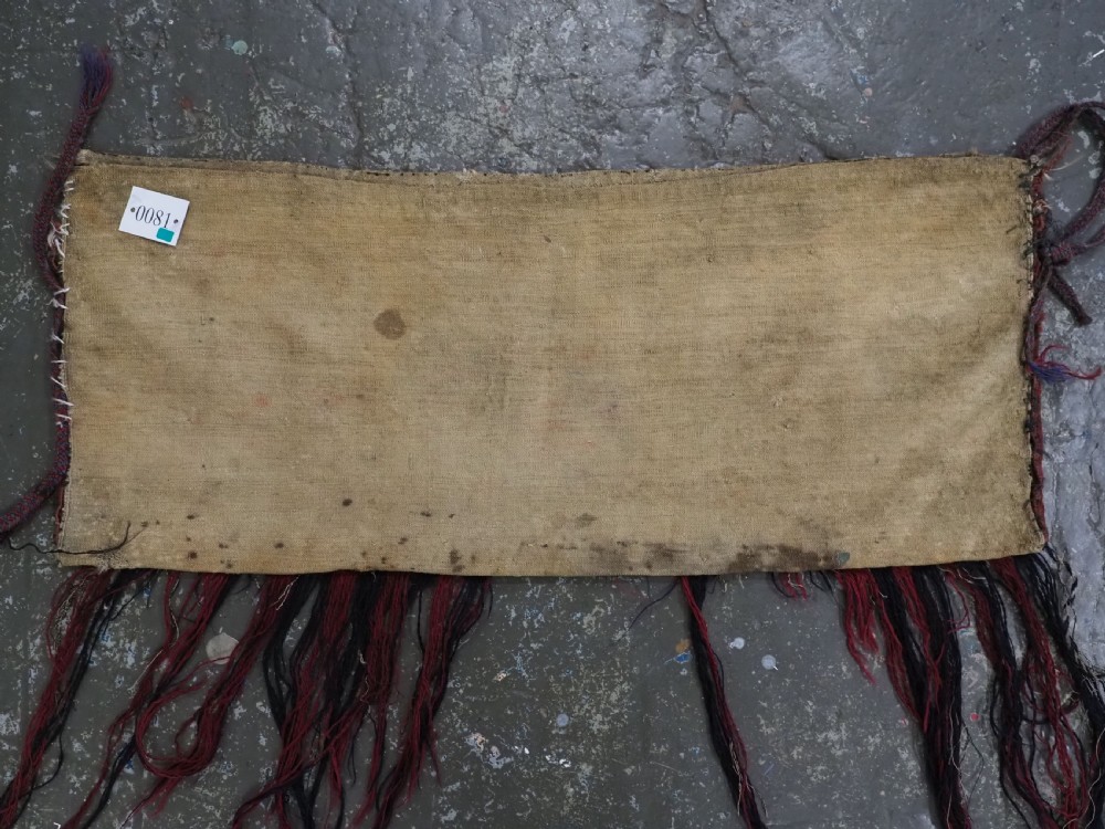 A horizontal rectangular handwoven wool Tekke Turkmen torba bag featuring nine geometric gul motifs in red, navy, and ivory, complete with a long hanging wool fringe at the base. View XIII
