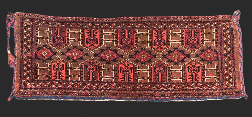An antique horizontal Saryk Turkmen torba face featuring geometric Kedjebe motifs woven in deep red, dark brown, and cream wool tones.