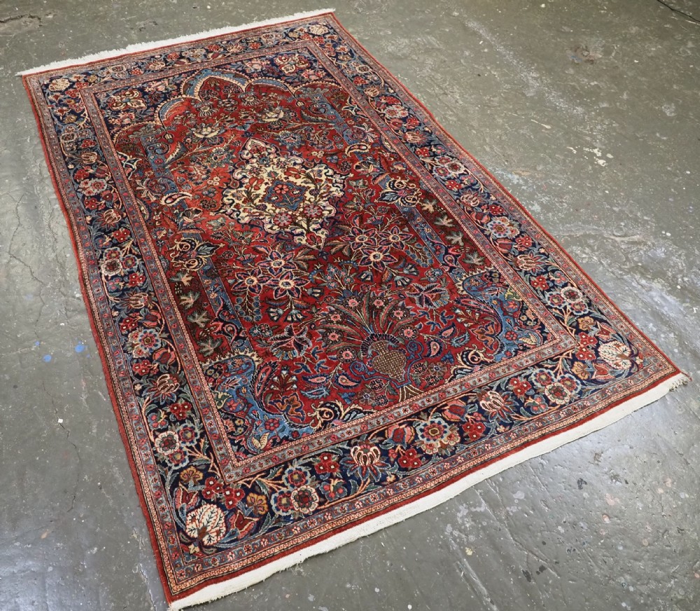 A hand-knotted wool Kashan prayer rug featuring a central floral medallion, a mihrab arch design, and intricate botanical borders in red, navy blue, and cream hues. View II