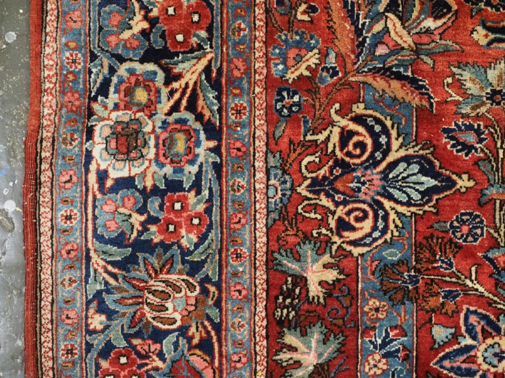 A hand-knotted wool Kashan prayer rug featuring a central floral medallion, a mihrab arch design, and intricate botanical borders in red, navy blue, and cream hues. View VI