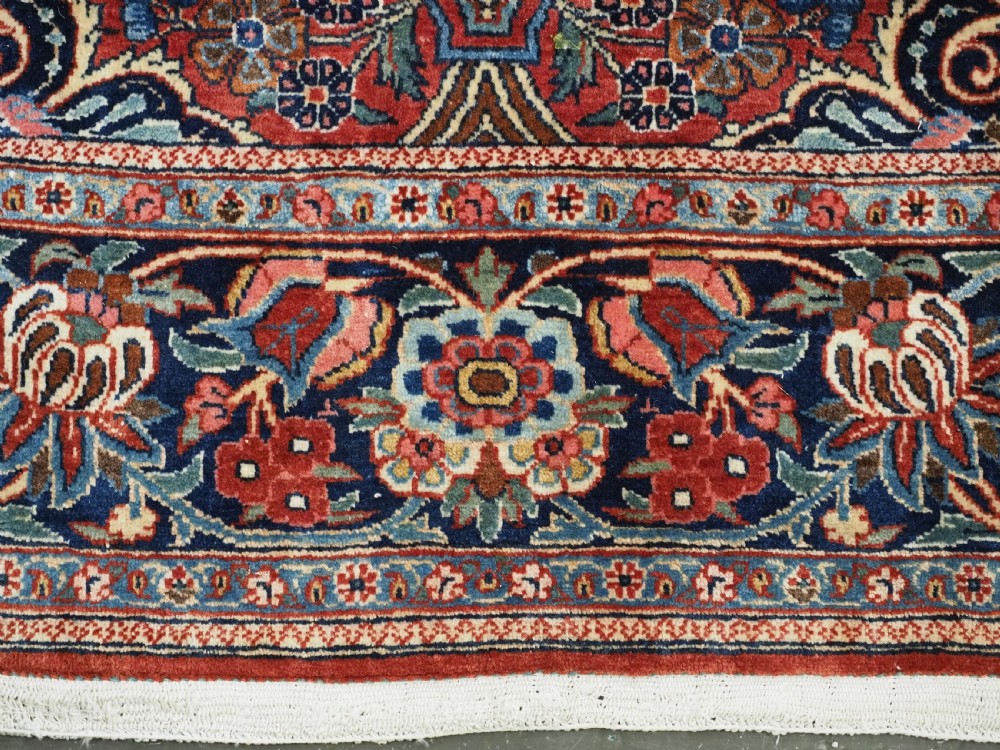A hand-knotted wool Kashan prayer rug featuring a central floral medallion, a mihrab arch design, and intricate botanical borders in red, navy blue, and cream hues. View XV