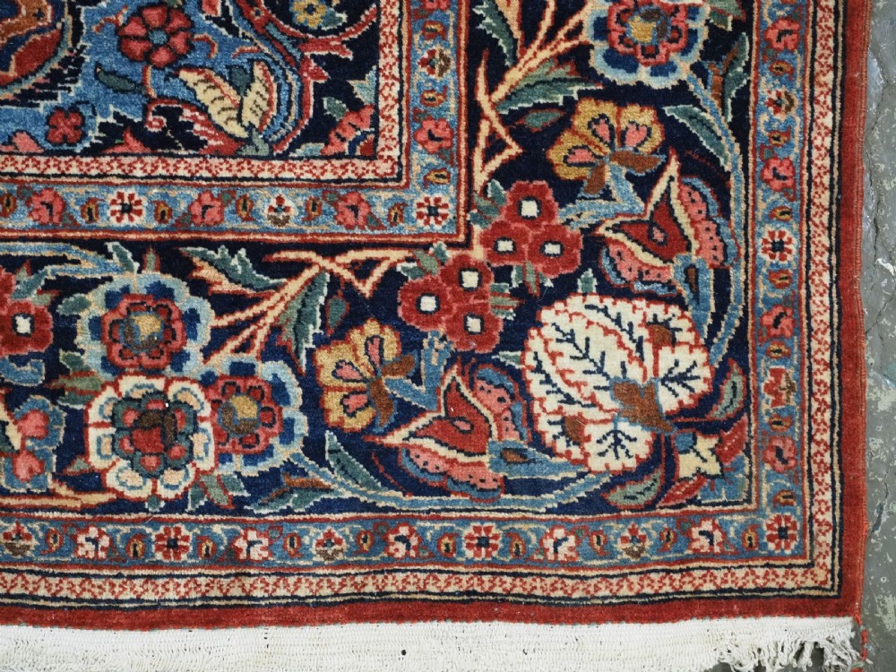 A hand-knotted wool Kashan prayer rug featuring a central floral medallion, a mihrab arch design, and intricate botanical borders in red, navy blue, and cream hues. View XVI