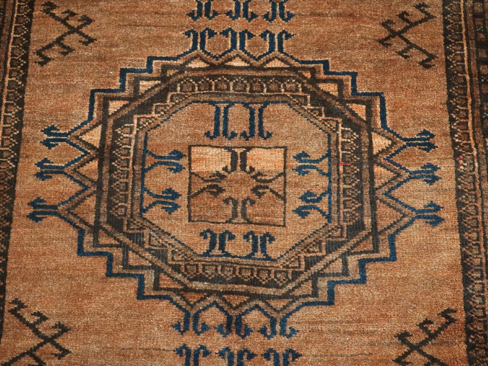 An antique long hand-knotted wool rug featuring four large central turreted octagonal guls on a terracotta field with geometric borders. View XI