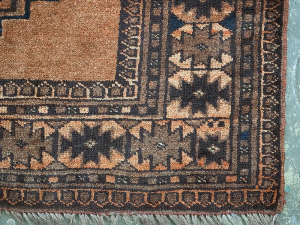 An antique long hand-knotted wool rug featuring four large central turreted octagonal guls on a terracotta field with geometric borders. View XIV