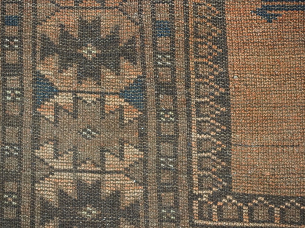 An antique long hand-knotted wool rug featuring four large central turreted octagonal guls on a terracotta field with geometric borders. View XV