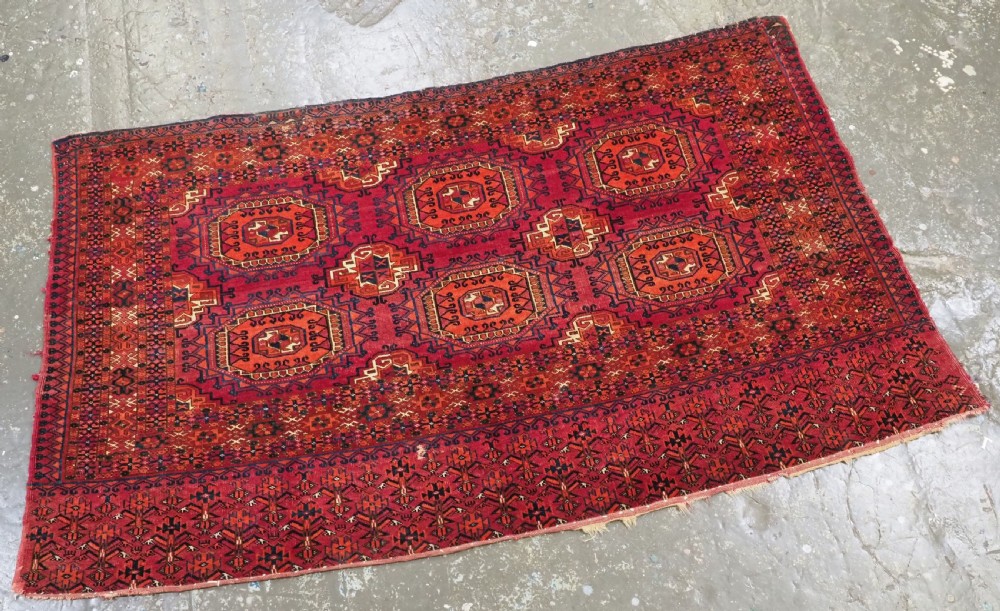 An antique Tekke Turkmen chuval face textile featuring six octagonal turreted guls framed by geometric borders in deep red, navy, and cream wool. View III