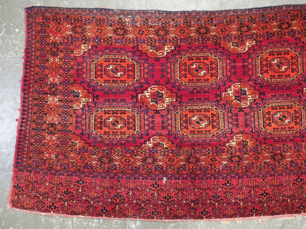 An antique Tekke Turkmen chuval face textile featuring six octagonal turreted guls framed by geometric borders in deep red, navy, and cream wool. View IV