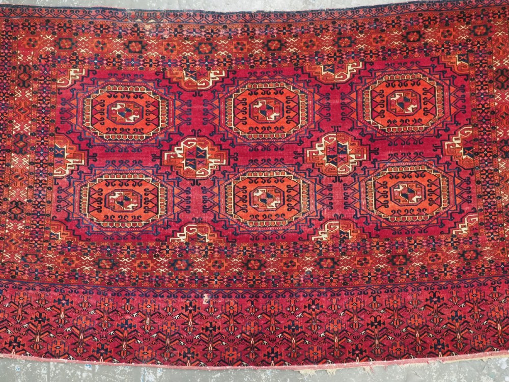 An antique Tekke Turkmen chuval face textile featuring six octagonal turreted guls framed by geometric borders in deep red, navy, and cream wool. View VI