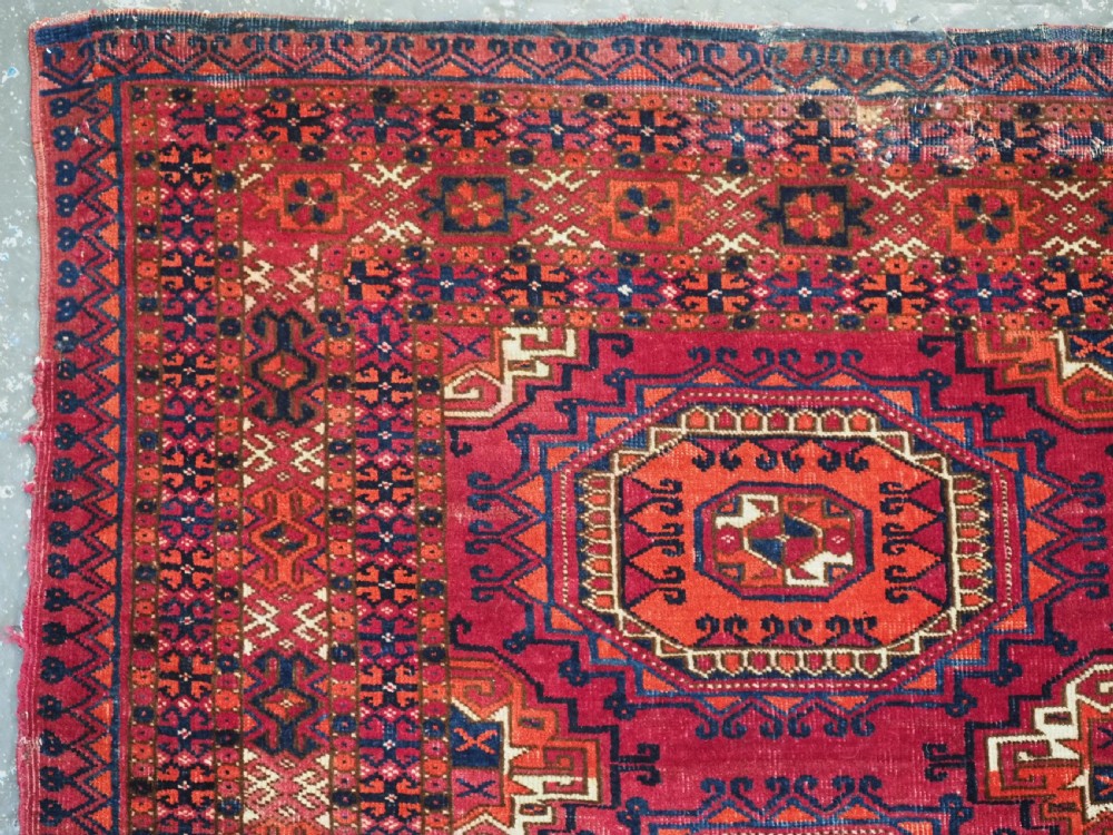 An antique Tekke Turkmen chuval face textile featuring six octagonal turreted guls framed by geometric borders in deep red, navy, and cream wool. View VII