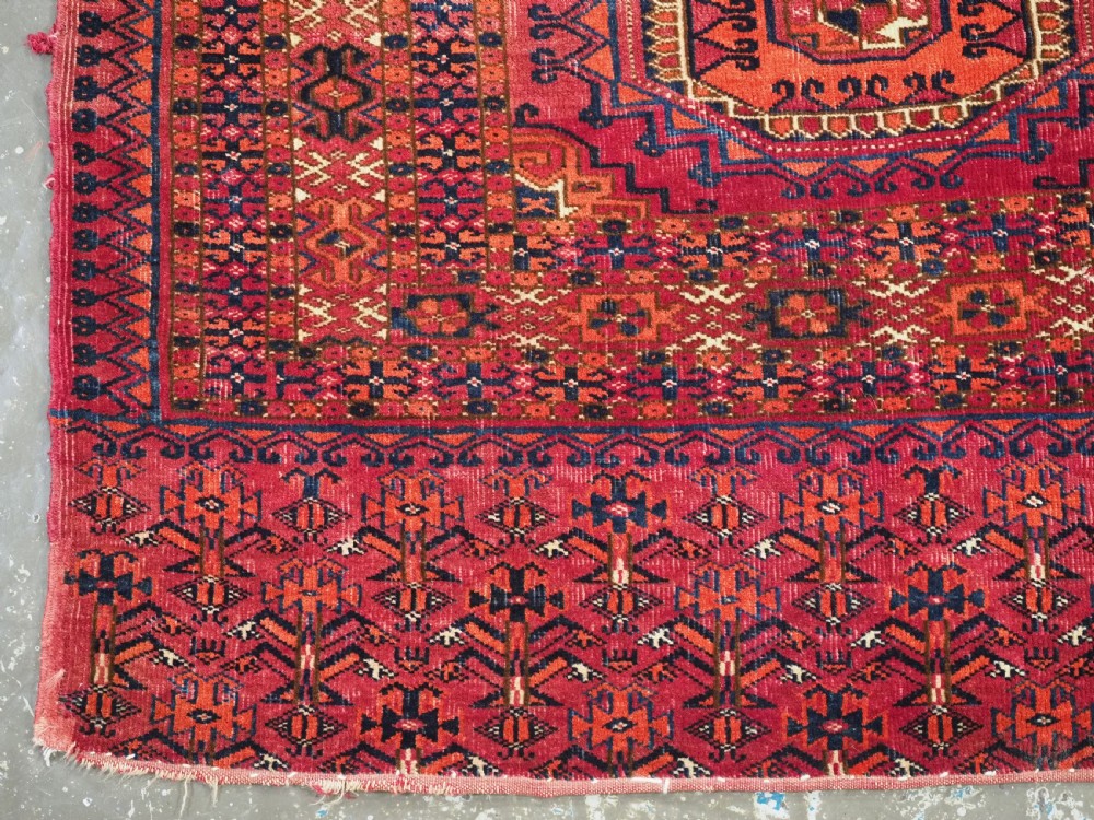An antique Tekke Turkmen chuval face textile featuring six octagonal turreted guls framed by geometric borders in deep red, navy, and cream wool. View VIII