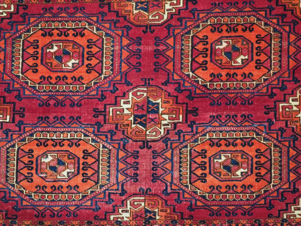 An antique Tekke Turkmen chuval face textile featuring six octagonal turreted guls framed by geometric borders in deep red, navy, and cream wool. View XII