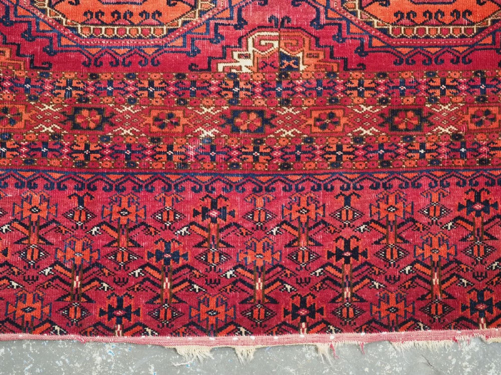 An antique Tekke Turkmen chuval face textile featuring six octagonal turreted guls framed by geometric borders in deep red, navy, and cream wool. View XIII