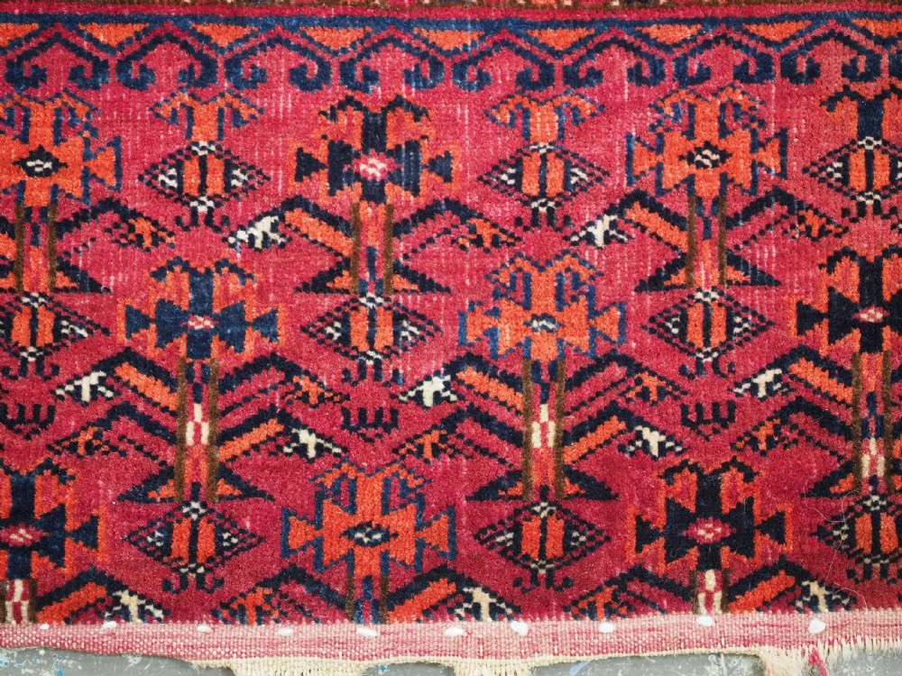 An antique Tekke Turkmen chuval face textile featuring six octagonal turreted guls framed by geometric borders in deep red, navy, and cream wool. View XIV
