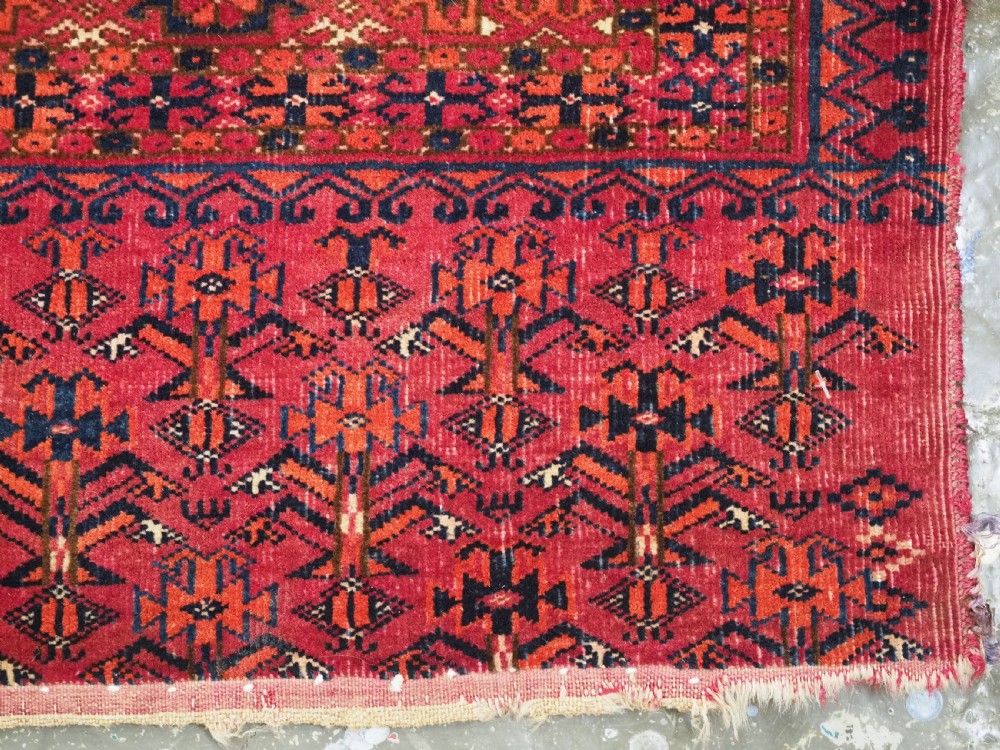 An antique Tekke Turkmen chuval face textile featuring six octagonal turreted guls framed by geometric borders in deep red, navy, and cream wool. View XVI