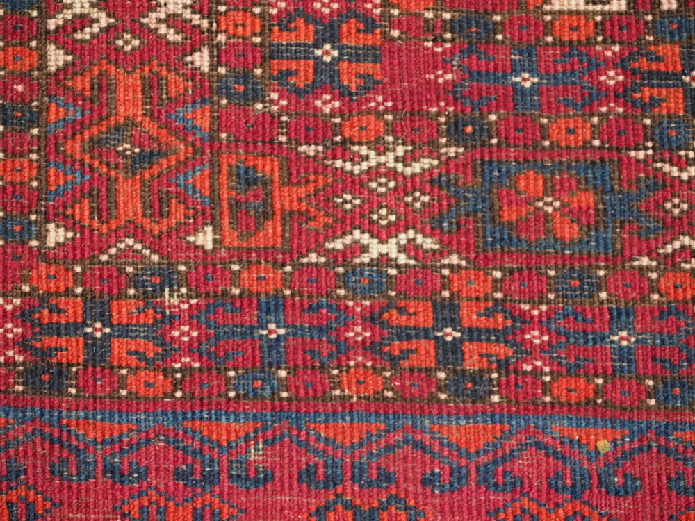 An antique Tekke Turkmen chuval face textile featuring six octagonal turreted guls framed by geometric borders in deep red, navy, and cream wool. View XVII