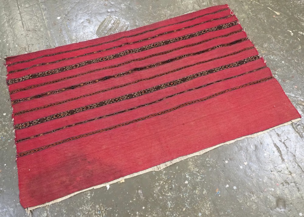 A rectangular red woven Turkmen Tekke chuval face featuring horizontal bands of geometric motifs. View II