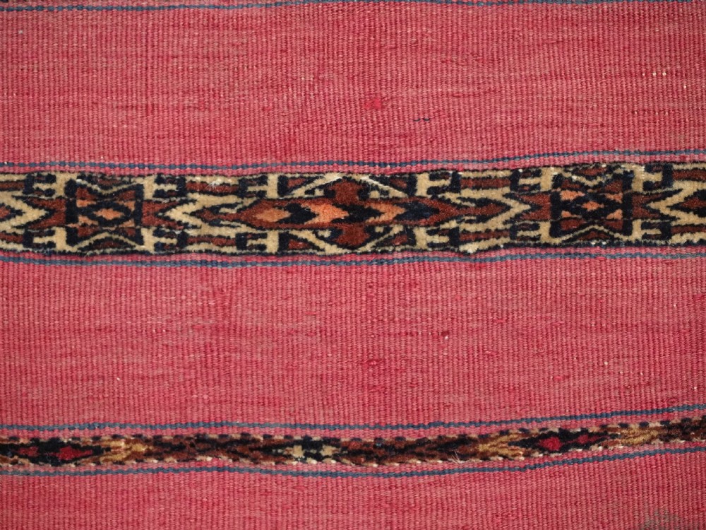 A rectangular red woven Turkmen Tekke chuval face featuring horizontal bands of geometric motifs. View VI