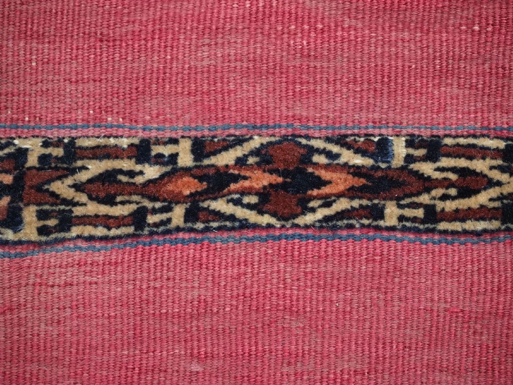 A rectangular red woven Turkmen Tekke chuval face featuring horizontal bands of geometric motifs. View IX