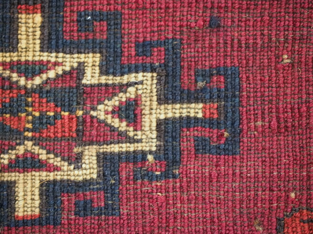 A horizontal crimson red Saryk Turkmen torba textile featuring octagonal Salor guls, intricate geometric borders, and a long dark lower fringe. View IX