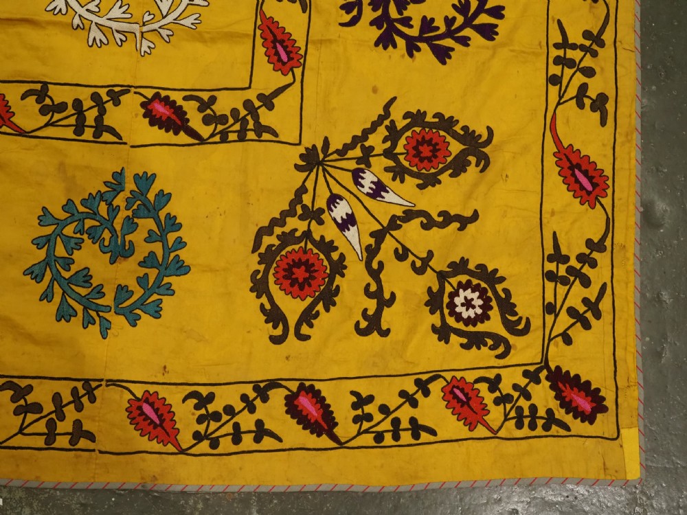ANTIQUE UZBEK SUZANI, SILK EMBROIDERY ON A YELLOW COTTON GROUND, CIRCA 1900. View X
