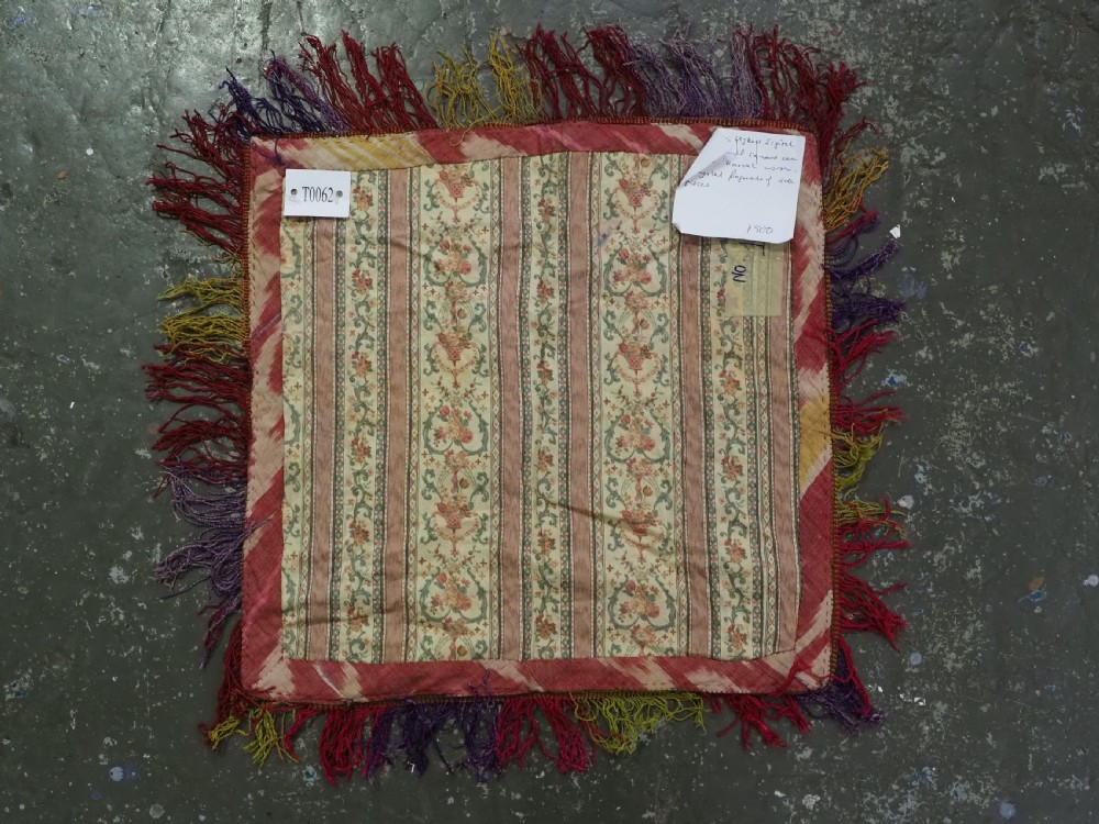 A square antique Uzbek Lakai embroidered textile featuring red cloth decorated with bright silk spiral motifs, geometric borders, and a multi-coloured fringe. View VI