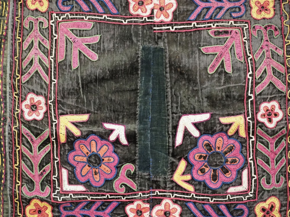 A square antique Uzbek Lakai embroidered panel featuring colourful silk floral motifs on a dark velvet ground, trimmed with a blue fringed border. View VII