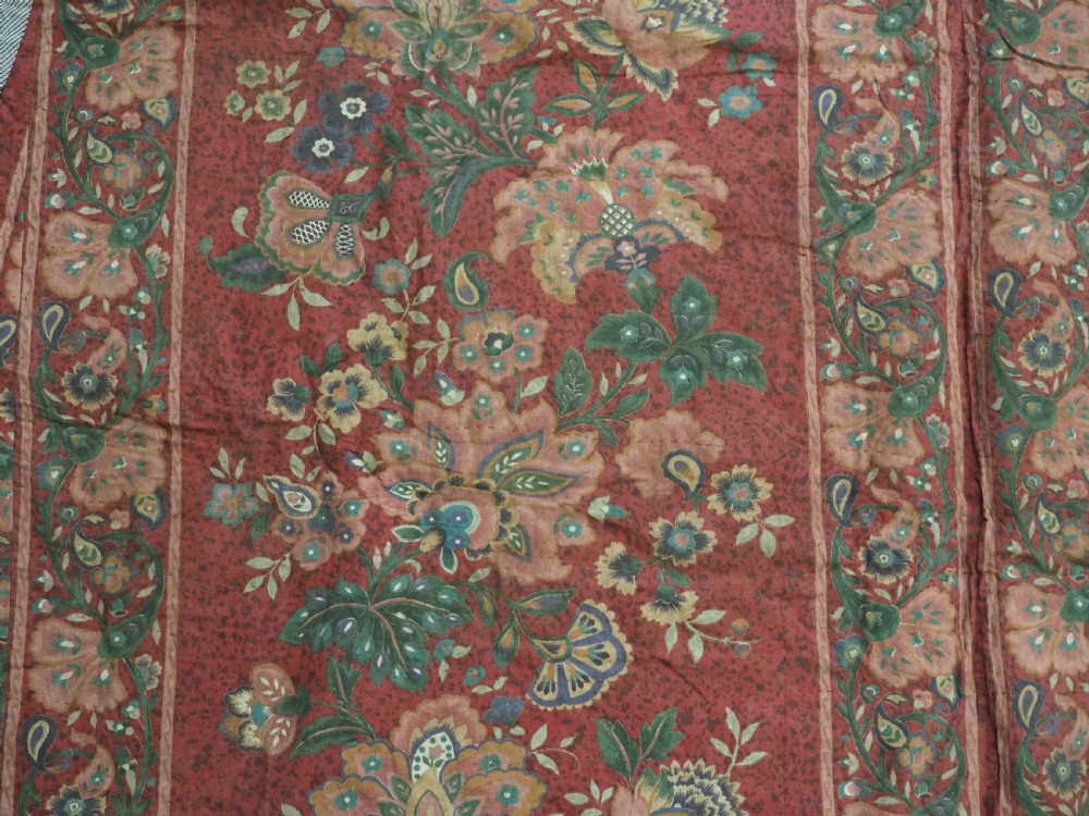 A trapezoidal Central Asian textile featuring dense multi-coloured floral, boteh, and horn embroidery on a red background with fringed edges. View XV