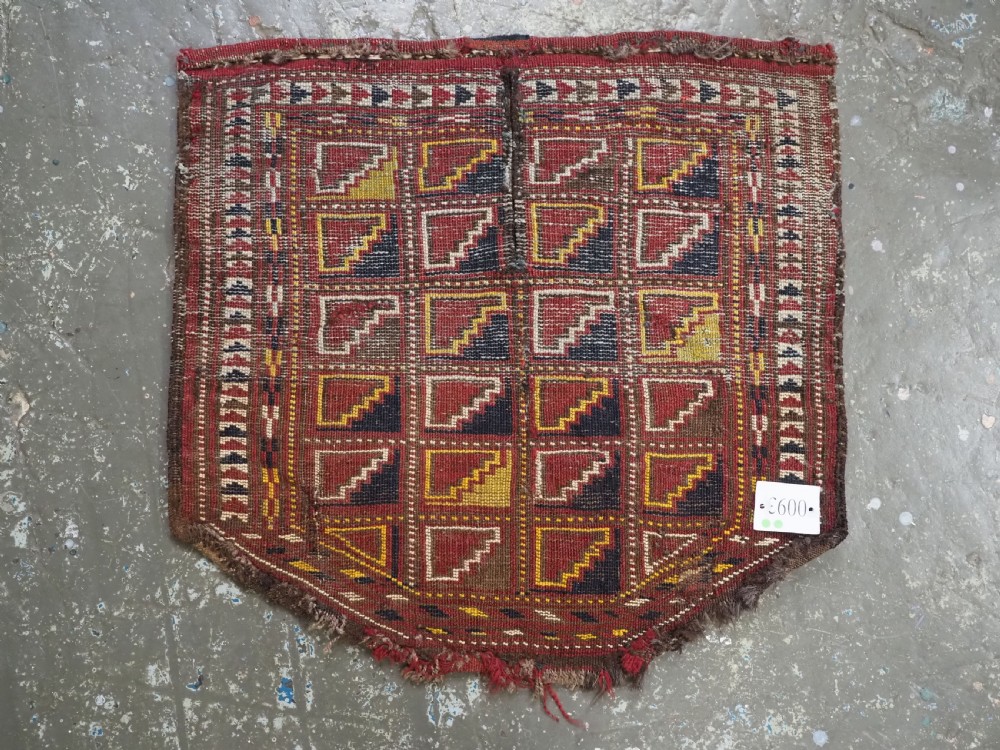 An antique Ersari Turkmen wool saddle cover featuring a grid layout of stepped geometric motifs in red, navy, yellow, and ivory. View VIII