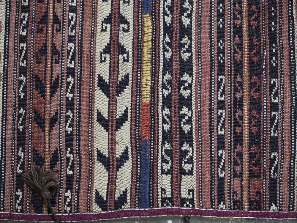 A flat-weave woven wool Northern Afghan ceremonial horse blanket featuring brown, cream, red, and blue geometric stripes with wool tassels along the edges. View X