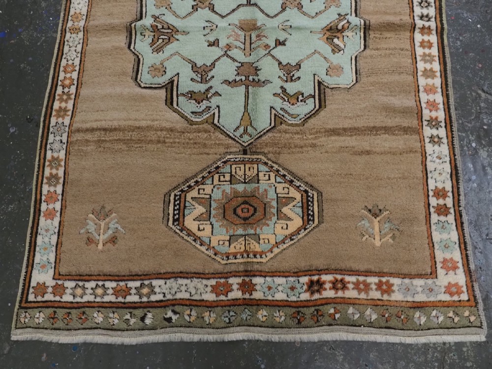 An antique hand-knotted Turkish Konya Karapinar rug featuring a camel wool field and geometric medallions in turquoise and terracotta. View VI