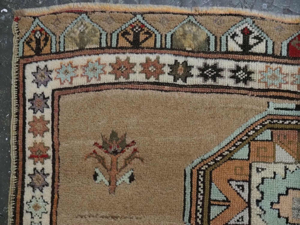 An antique hand-knotted Turkish Konya Karapinar rug featuring a camel wool field and geometric medallions in turquoise and terracotta. View VII