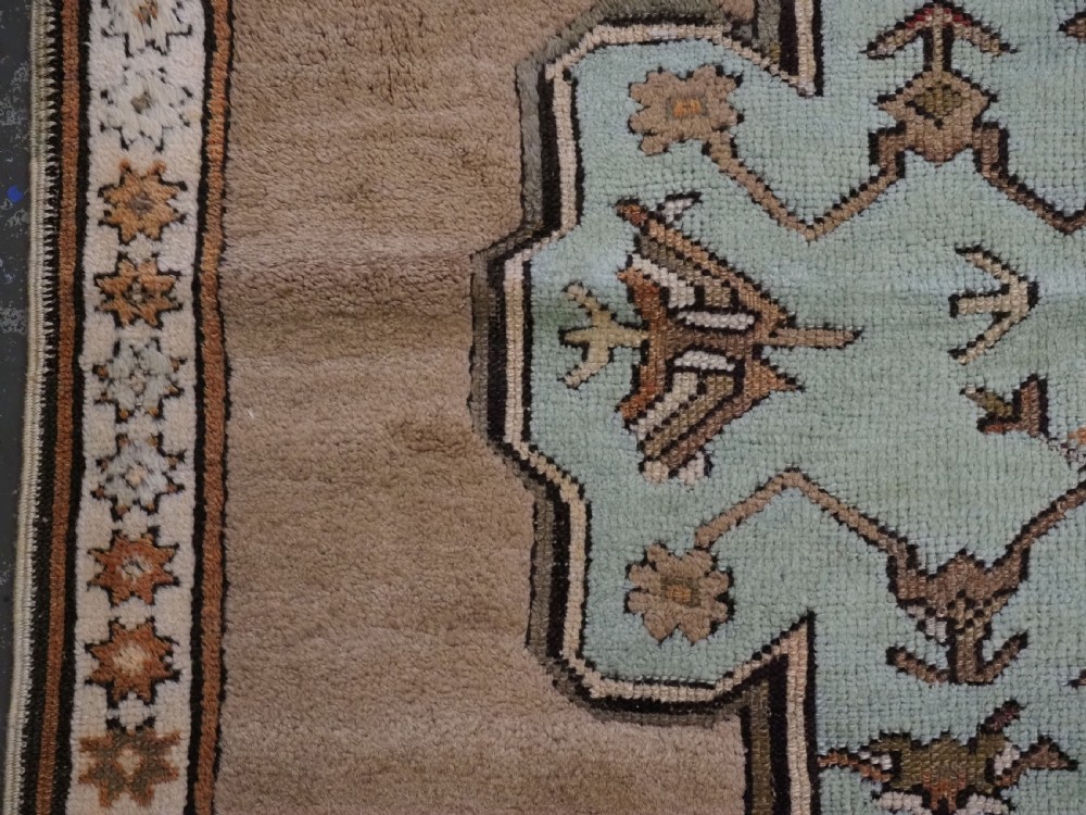 An antique hand-knotted Turkish Konya Karapinar rug featuring a camel wool field and geometric medallions in turquoise and terracotta. View VIII