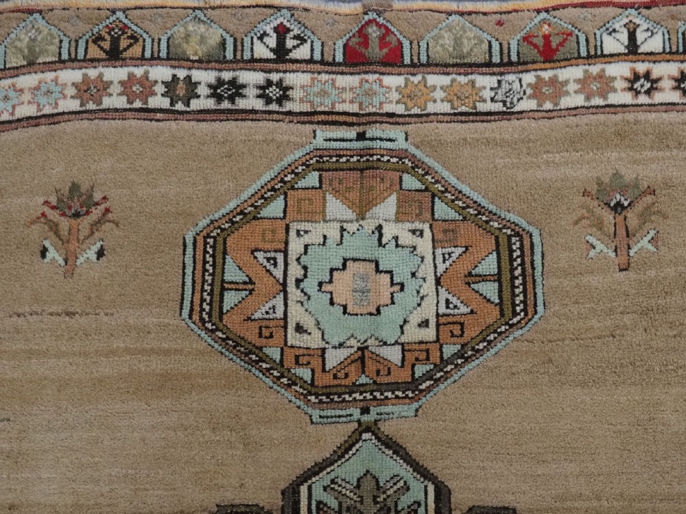 An antique hand-knotted Turkish Konya Karapinar rug featuring a camel wool field and geometric medallions in turquoise and terracotta. View IX