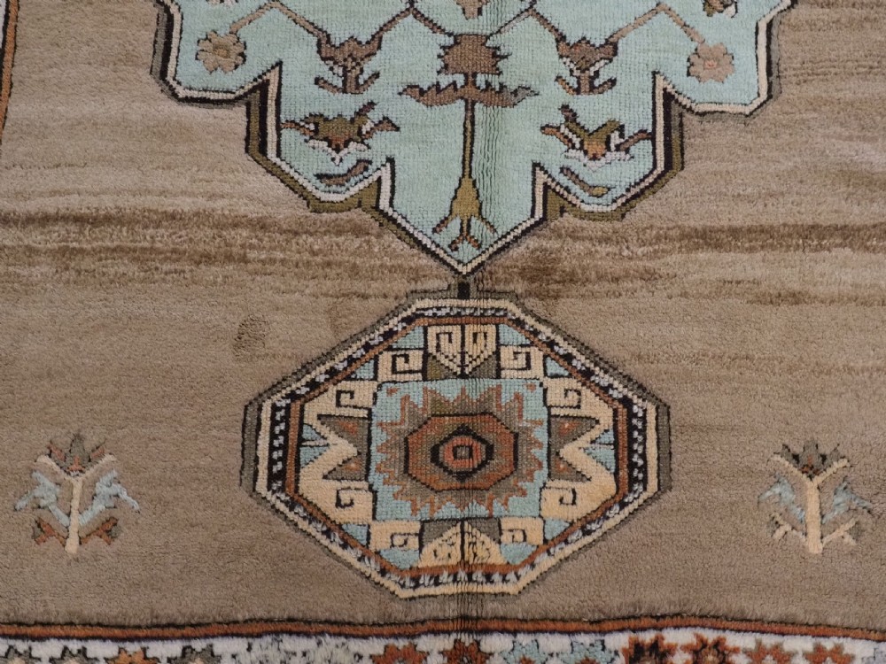 An antique hand-knotted Turkish Konya Karapinar rug featuring a camel wool field and geometric medallions in turquoise and terracotta. View XI