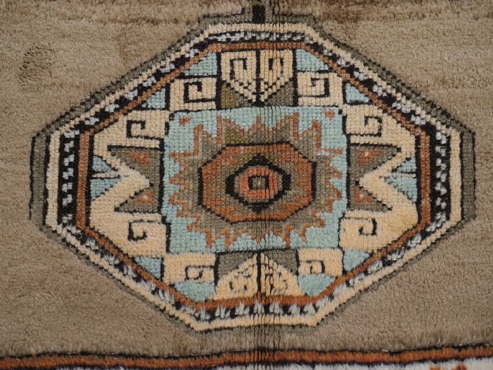 An antique hand-knotted Turkish Konya Karapinar rug featuring a camel wool field and geometric medallions in turquoise and terracotta. View XII