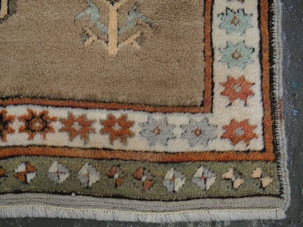 An antique hand-knotted Turkish Konya Karapinar rug featuring a camel wool field and geometric medallions in turquoise and terracotta. View XV
