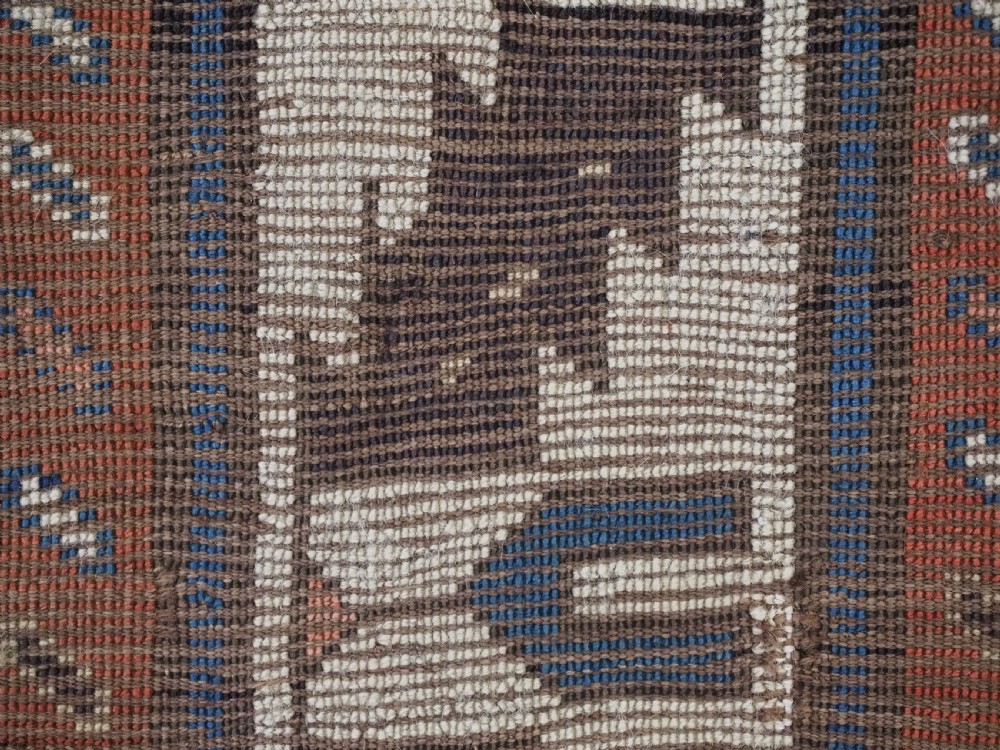 An antique Caucasian wool rug runner featuring a central geometric lattice pattern in navy blue and cream within multiple decorative borders. View XVI
