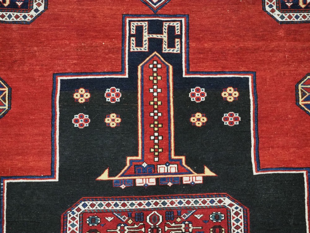 An antique Caucasian Konagkend hand-knotted wool rug featuring a large dark cruciform central medallion on a deep red ground with geometric borders and fringe. View X