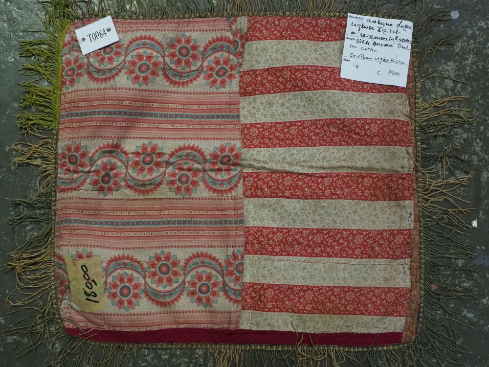 A square antique Uzbek Lakai tribe ilgich embroidery featuring multi-coloured floral and scroll motifs on a red background with fringed edges. View VIII