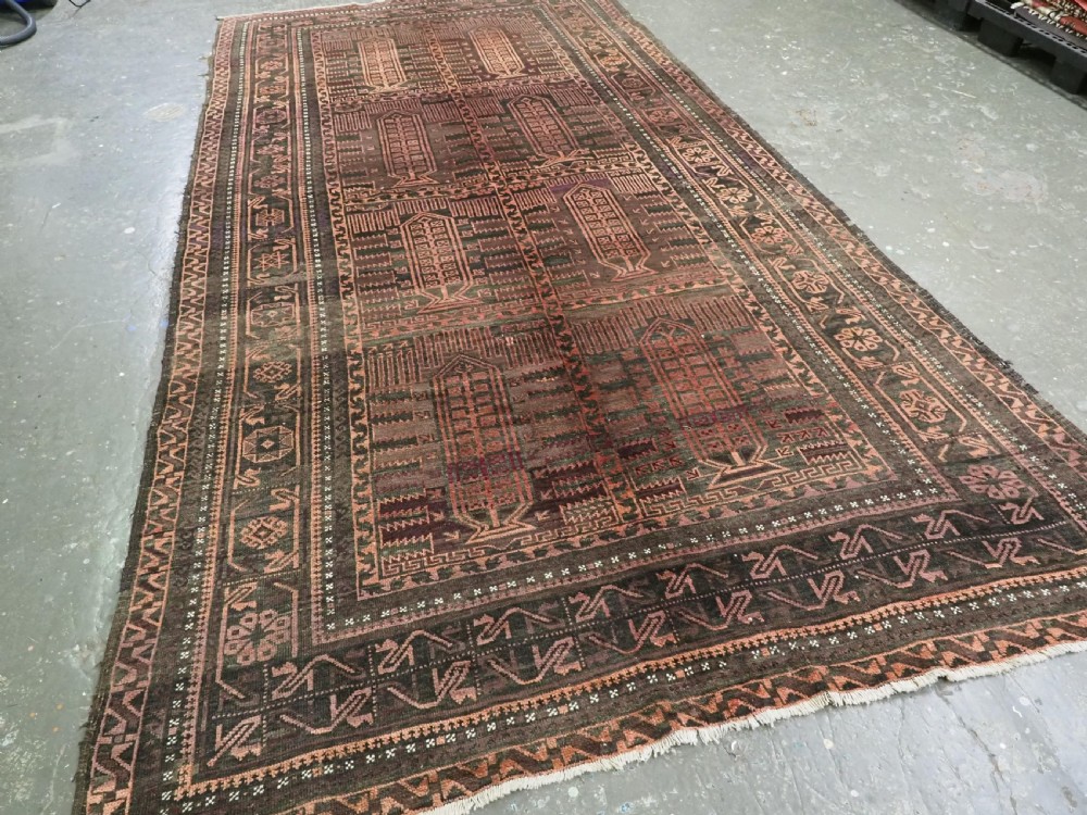 A long, dark-toned hand-knotted wool rug displaying a repeating geometric pencil box motif within complex outer geometric borders. View II