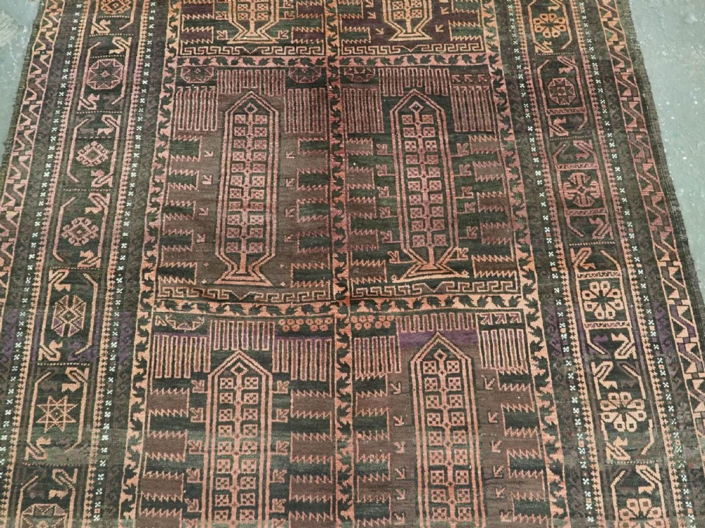 A long, dark-toned hand-knotted wool rug displaying a repeating geometric pencil box motif within complex outer geometric borders. View IV